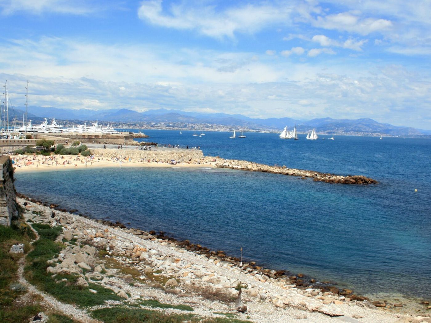Les remparts d’Antibes, la plage de la Gravette et la baie, les Alpes au fond — Antibes · Juan-les-Pins