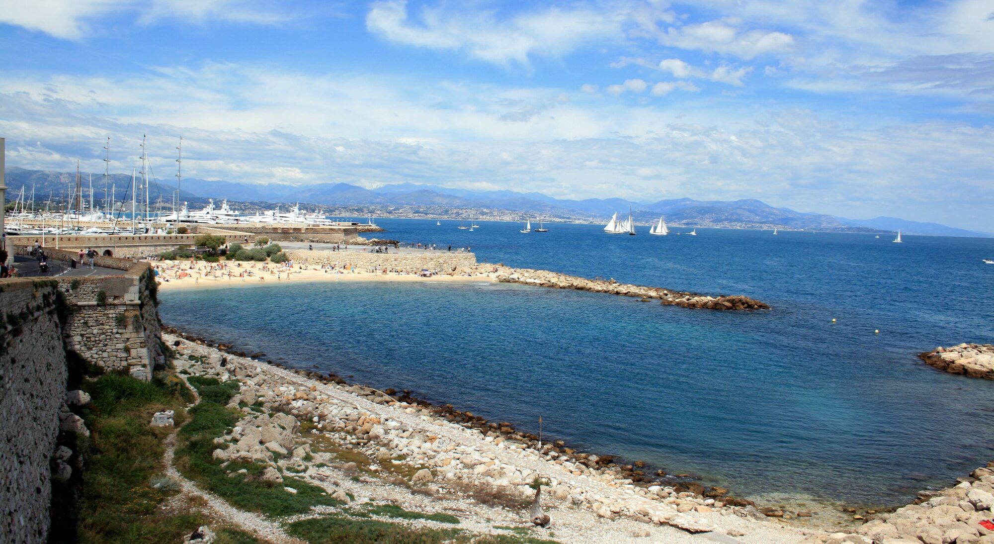 Les remparts d’Antibes, la plage de la Gravette et la baie, les Alpes au fond — Antibes